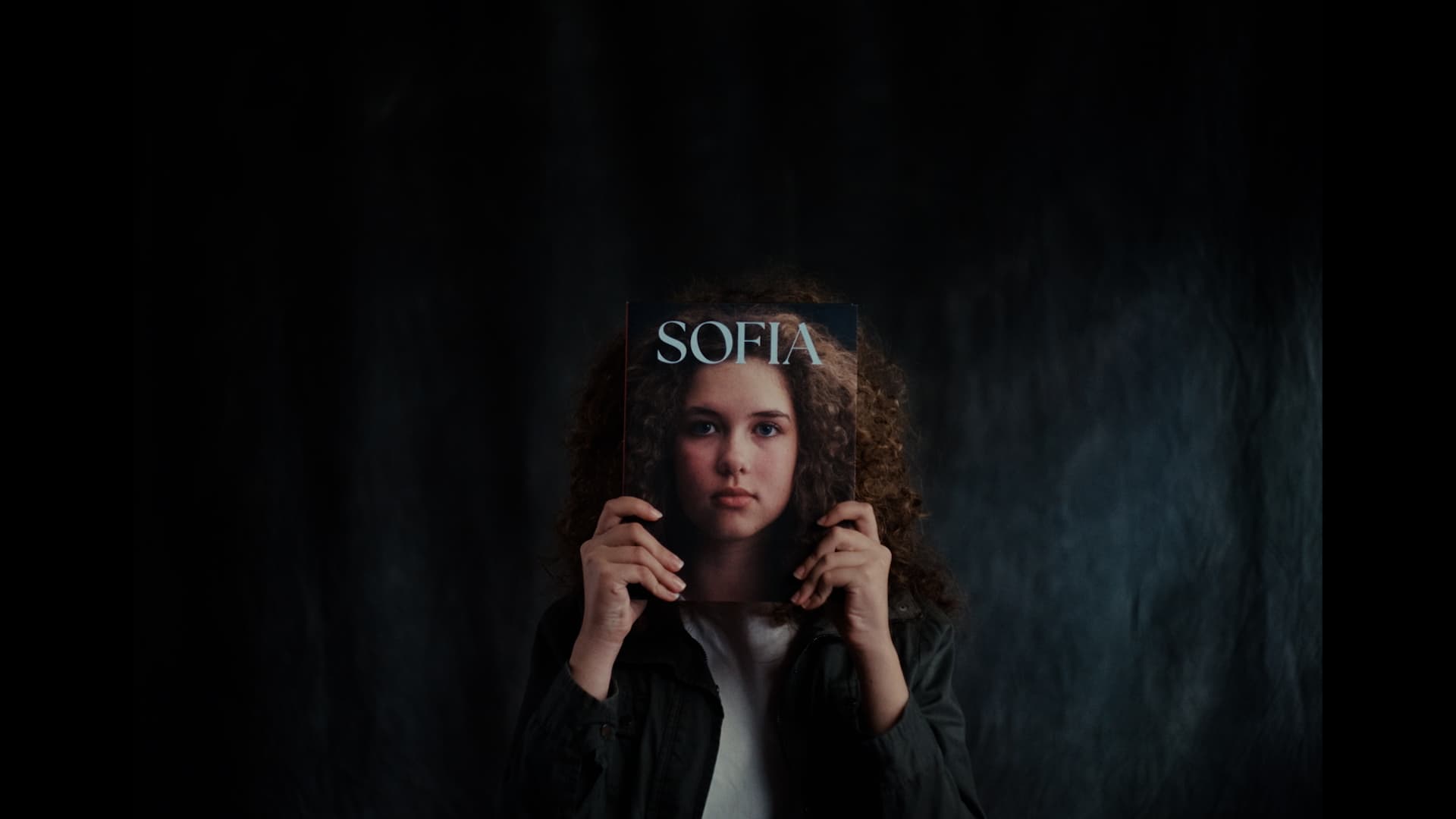 girl called sofia holding up a book with her name and face on it 